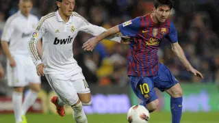 Ozil y Messi pugnan por el balón