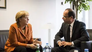 Merkel y Hollande conversan en un momento de la cumbre