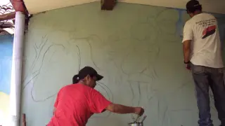 Unos jóvenes pintan un mural en León