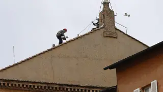 Operarios cubren el tejado de la Capilla Sixtina tras retirar la chimenea