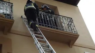 Los bomberos accediendo al interior de la vivienda afectada por el balcón.