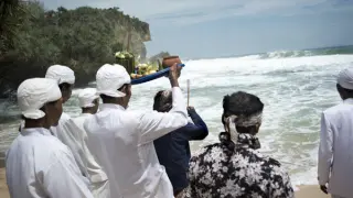 Sacerdotes alzando sus ofrendas antes de depositarlas en el mar