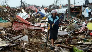 Un hombre avanza entre los destrozos provocados por el tifón