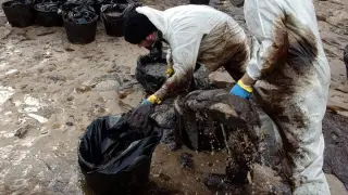 Voluntarios limpiando el chapapote tras el hundimiento del Prestige.