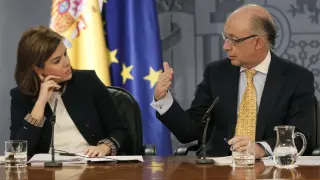 La vicepresidenta del Gobierno, Soraya Sáenz de Santamaría, escucha al ministro de Hacienda, Cristóbal Montoro