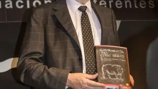 El experto en gastronomía Ismael Díaz Yubero muestra un ejemplar de su libro 'Gastronomía del cerdo ibérico'