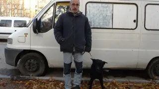 Santos con su perra, junto a la furgoneta en la que viven.