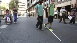 Niños experimentando las dificultades que conlleva ser ciego en la Semana de la Movilidad, en Huesca