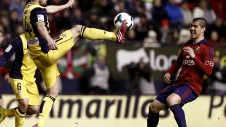El centrocampista del Atlético de Madrid Gabi (i) trata de controlar un balón ante el chileno Silva, de Osasuna.