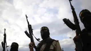 Varios militantes de la yihad islámica alzan sus armas durante un funeral