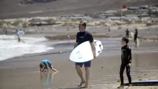 David Cameron con una tabla de surf en la playa