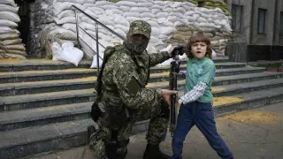 Un niño posa con un soldado en las calles de Kiev