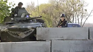 Varios soldados ucranianos vigilan, desde detrás de un muro, en un puesto de control situado a 30 kilómetros de la ciudad de Slaviansk