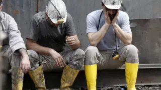 Dos mineros se toman un descanso en las labores de rescate de sus compañeros