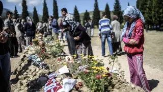 Familiares de las víctimas lloran ante sus tumbas