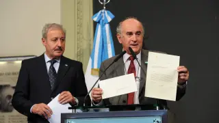 Dos representantes del Gobierno argentino muestran la carta la la prensa