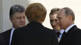 Putin y Poroshenko dialogan ante la mirada de Merkel