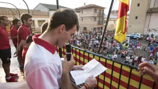 Uno de los jugadores del Villanueva C. F. lee el pregón en el balcón del Ayuntamiento.
