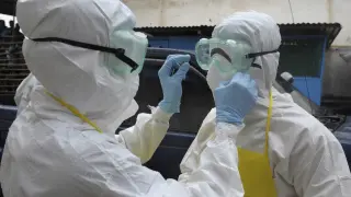 Trabajadores sanitarios se colocan las prendas protectoras para evitar el contagio