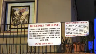 Cartel de los vecinos a los turistas en un balcón del barrio