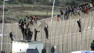 Agentes de la Guardia Civil intentan hacer bajar a los inmigrantes encaramados