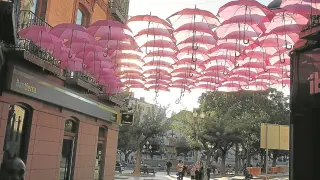 Paraguas rosas colgados en al calle de Berenguer, en Huesca, cerca de la sede de la AECC.