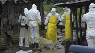 Trabajadores sanitarios se preparan para trasladar el cuerpo de un fallecido de ébola en Monrovia.