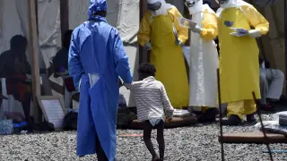 Una enfermera camina de la mano de una niña pequeña enferma de ébola, en un Centro de Médicos Sin Fronteras de Monrovia.