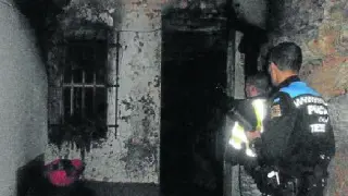 Dos policías locales revisan la casa tras el incendio