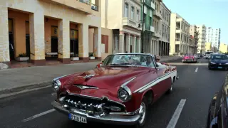 Unos turistas viajan en un coche antiguo en el centro de La Habana