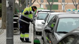 Un trabajador de FCC barre la calle en la travesía de Ballesteros de Huesca.