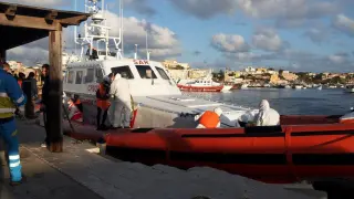 Un barco de la Guardia Costera italiana, con inmigrantes a bordo, llega al puerto de Lampedusa