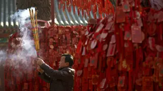 Un hombre pide buena fortuna durante la celebración del Año Nuevo Chino
