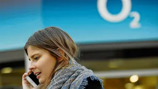 Una mujer habla por el móvil junto a la sede de una tienda de O2 en Londres.
