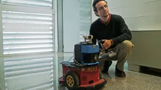 José Neira con uno de los robots con los que trabaja en su departamento