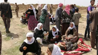 Un grupo de mujeres yazidíes espera en un punto de control tras haber sido liberadas