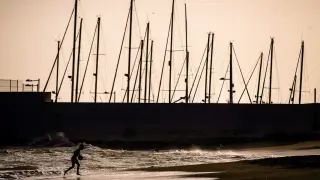 Un niño juega a la pelota en la playa de La Venus, de Málaga, donde tres jóvenes de nacionalidad turca de 18, 19 y 30 años de edad, los dos primeros sordomudos y el tercero monitor del grupo de discapacitados, han fallecido hoy ahogados