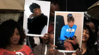 Varias mujeres muestran fotografías de las víctimas