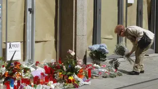 Una mujer deja flores a las puertas del instituto Joan Fuster de Barcelona