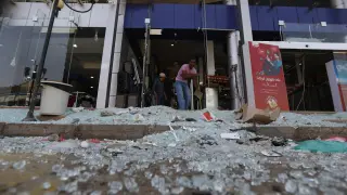 Varios yemeníes limpian los desperfectos causados por un bombardeo por la coalición árabe en Saná