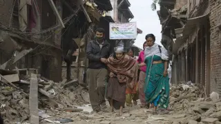 Varios nepalíes recogen algunas pertenencias de entre los escombros