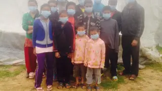 Niños en uno de los centros de acogida de Katmandú se protegen del polvo y el olor