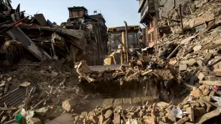 Una excavadora retira escombros en una localidad de Nepal