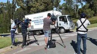 Reporteros graban un vehículo saliendo de la residencia rentada en Australia.