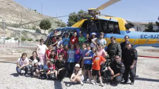 Un grupo de escolares posa junto al helicóptero de la DGT.