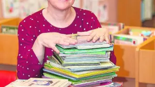 Carmen Carramiñana, feliz, rodeada de libros infantiles.
