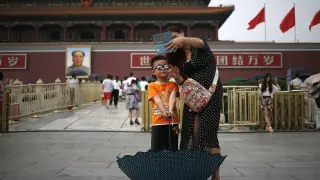 Un niño y su madre se hacen una foto frente a la Ciudad Prohibida.