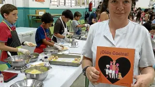 Enriqueta Pac, con el libro junto a los alumnos en un taller de cocina.