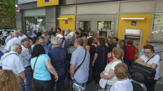 Pensionistas hacen cola para retirar dinero a la entrada de una sucursal bancaria en Salónica.