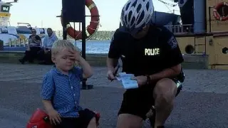 El agente pone una multa en su libreta al niño de tres años por aparcar mal su moto de juguete